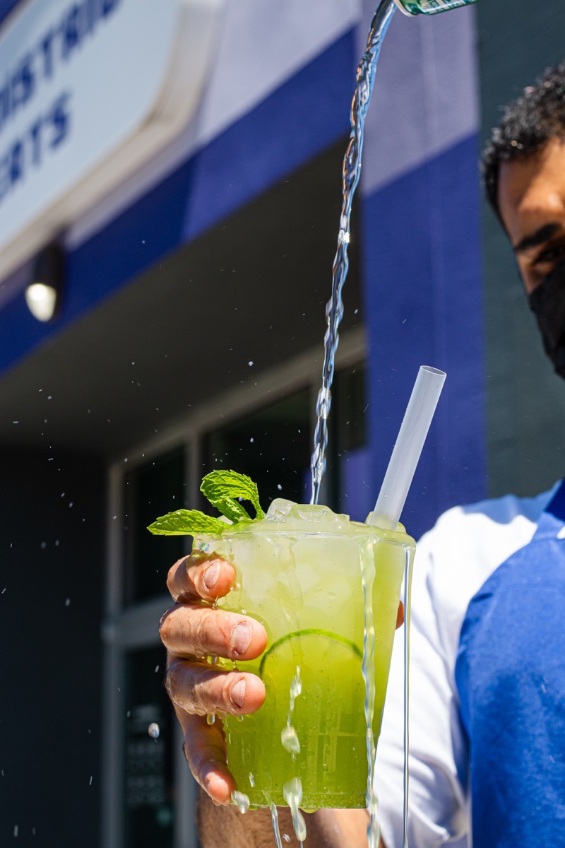 Mint lemonade being poured into a glass outside a restaurant