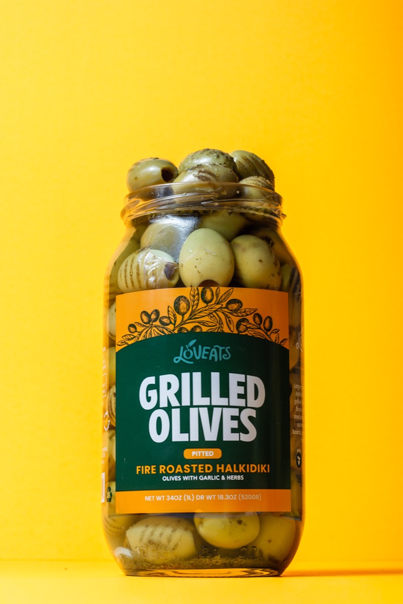 Loveeats grilled olives jar photographed on yellow