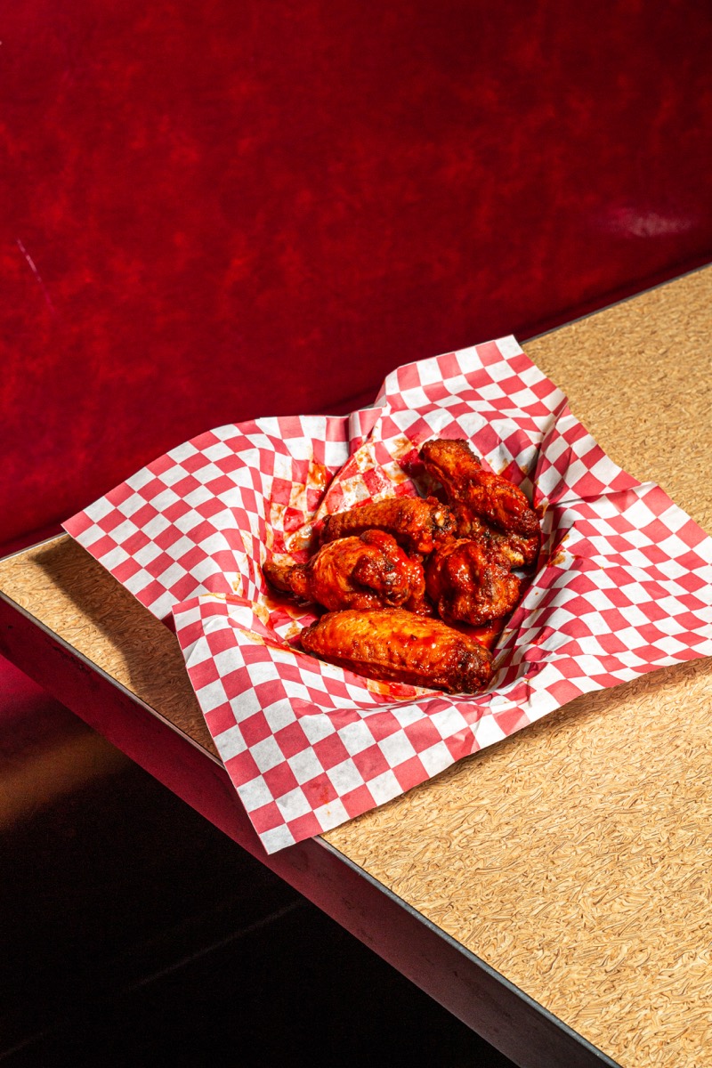 Basket of saucy chicken wings in a restaurant booth